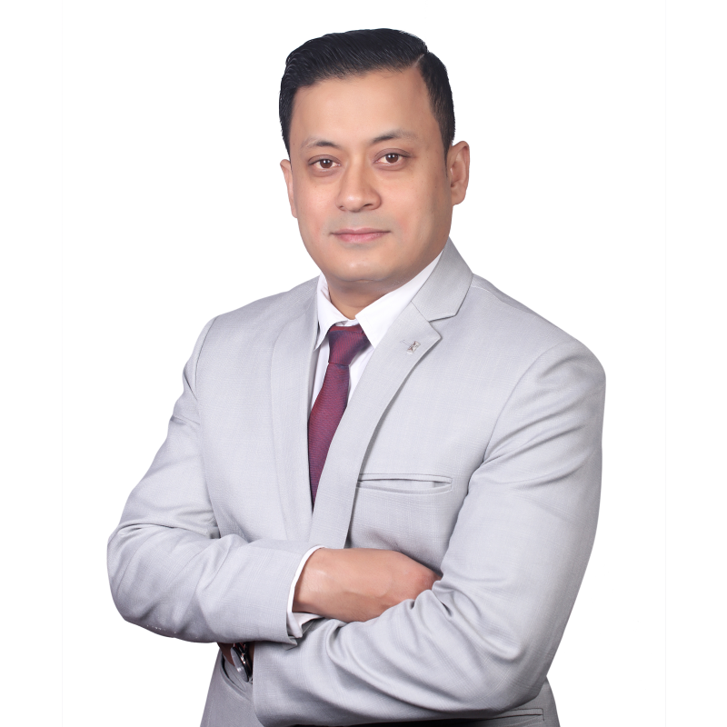 Sanir Kumar Maharjan, Managing Director of Visa Alliance Nepal, in a professional portrait wearing a gray suit and maroon tie.